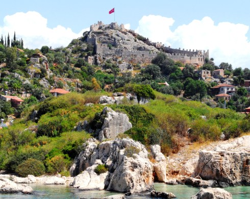 Color photo of a hillside castle on a small island.