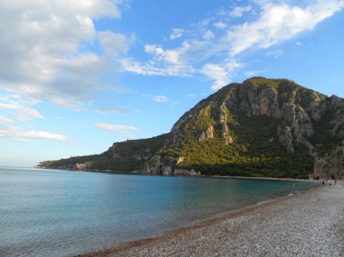 Color photo of beachscape in Chirali.  Mountains landing into the Mediterranean Sea.