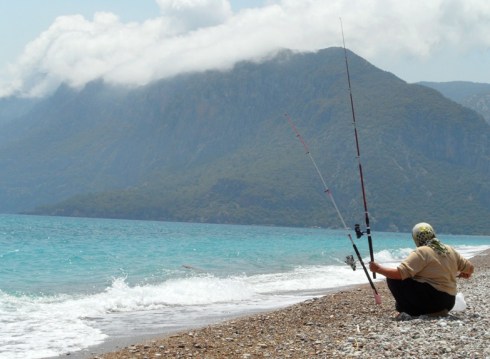 woman fishing on the edge of the sea