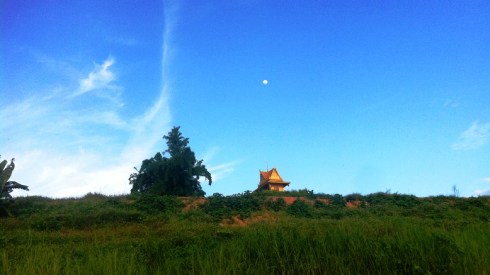 Color photo of the moon rising over the Mekong River near the Laos-Thai border