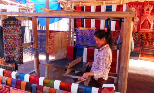 Women weaving a silk scarf in her street stall